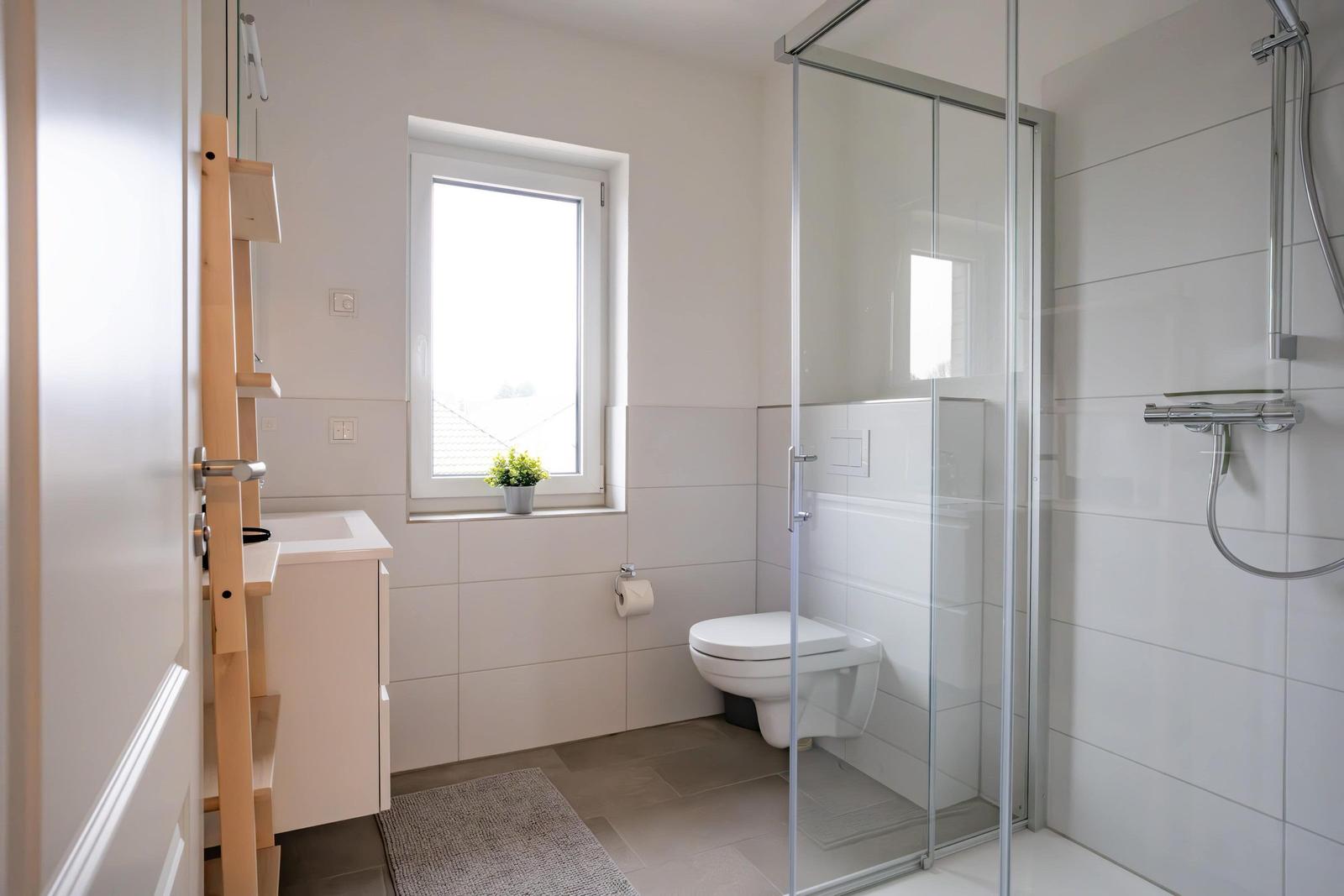 Badezimmer mit Dusche, Toilette und Waschbecken.