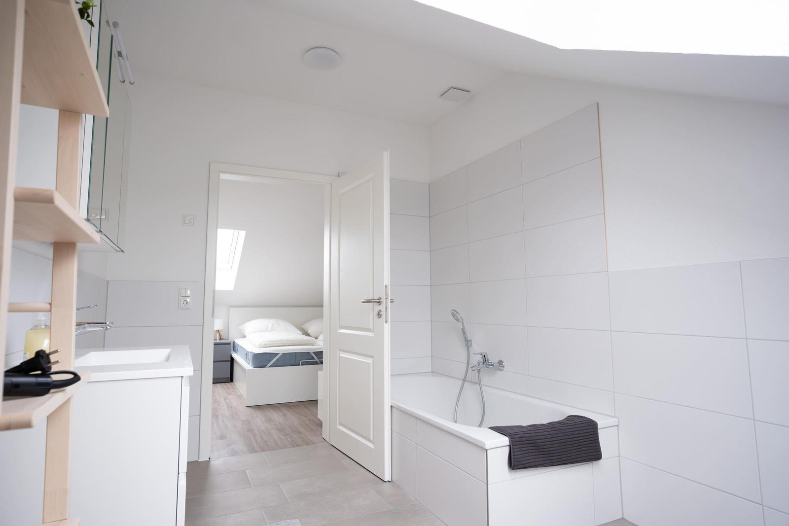 Badezimmer mit Badewanne und Blick in das Schlafzimmer