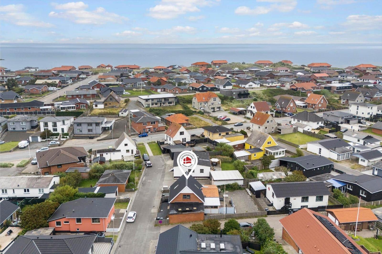 Luftbild einer Küstenstadt mit vielen Häusern und Blick auf das Meer.