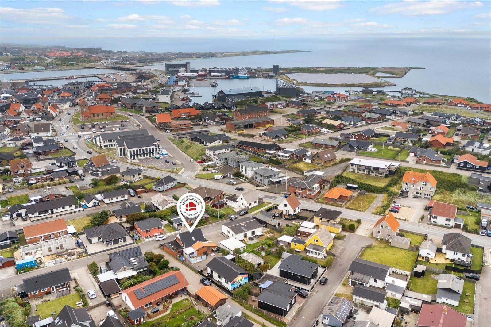 Luftbild von Nidde Sange mit Häusern, Straßen und Hafenansicht.