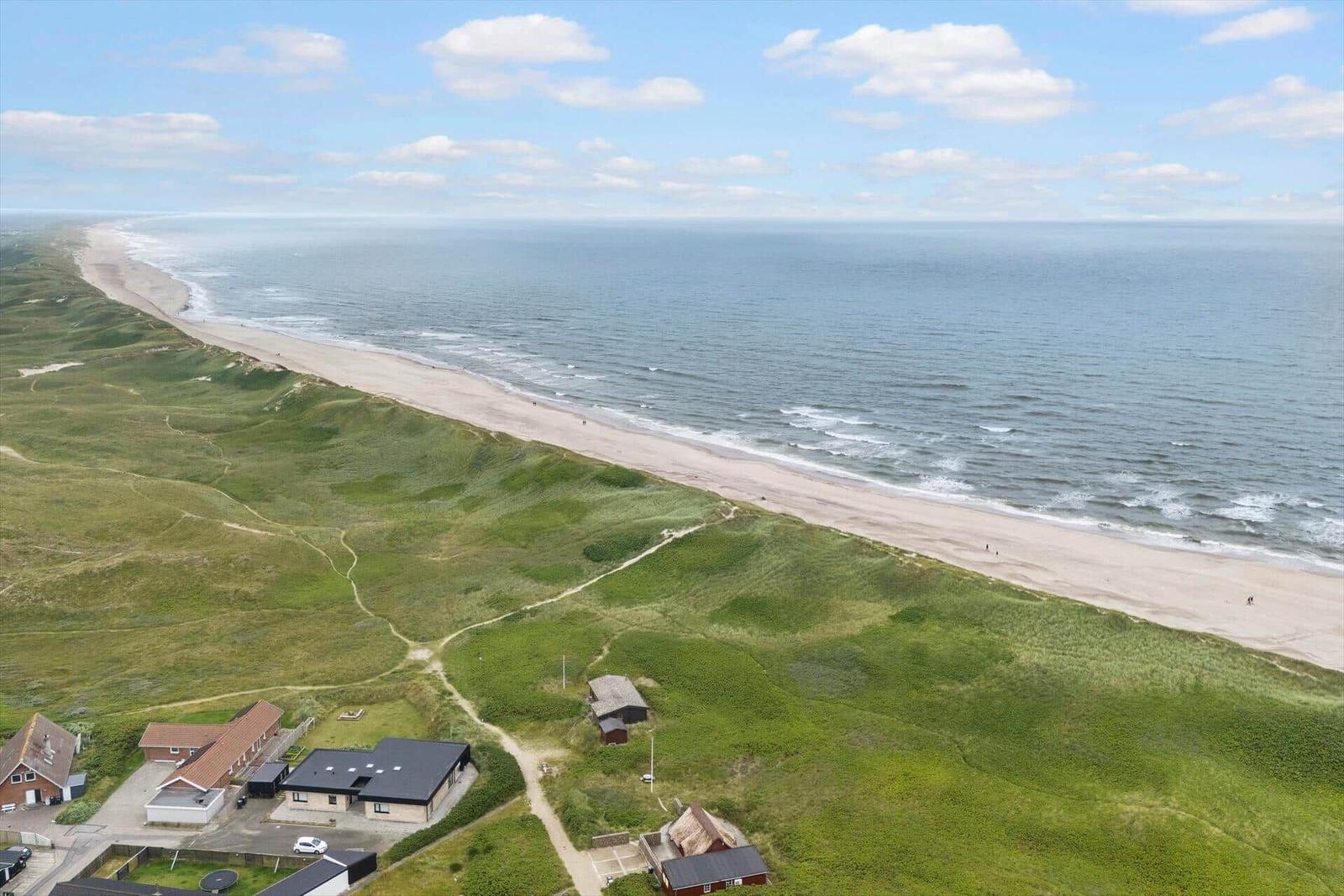 Strand mit Dünen und Häusern in der Ferne