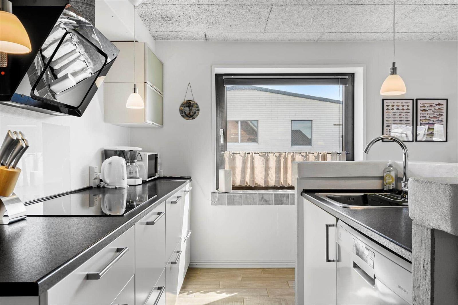 Moderne Küche mit Arbeitsplatte, Spüle und Fenster.