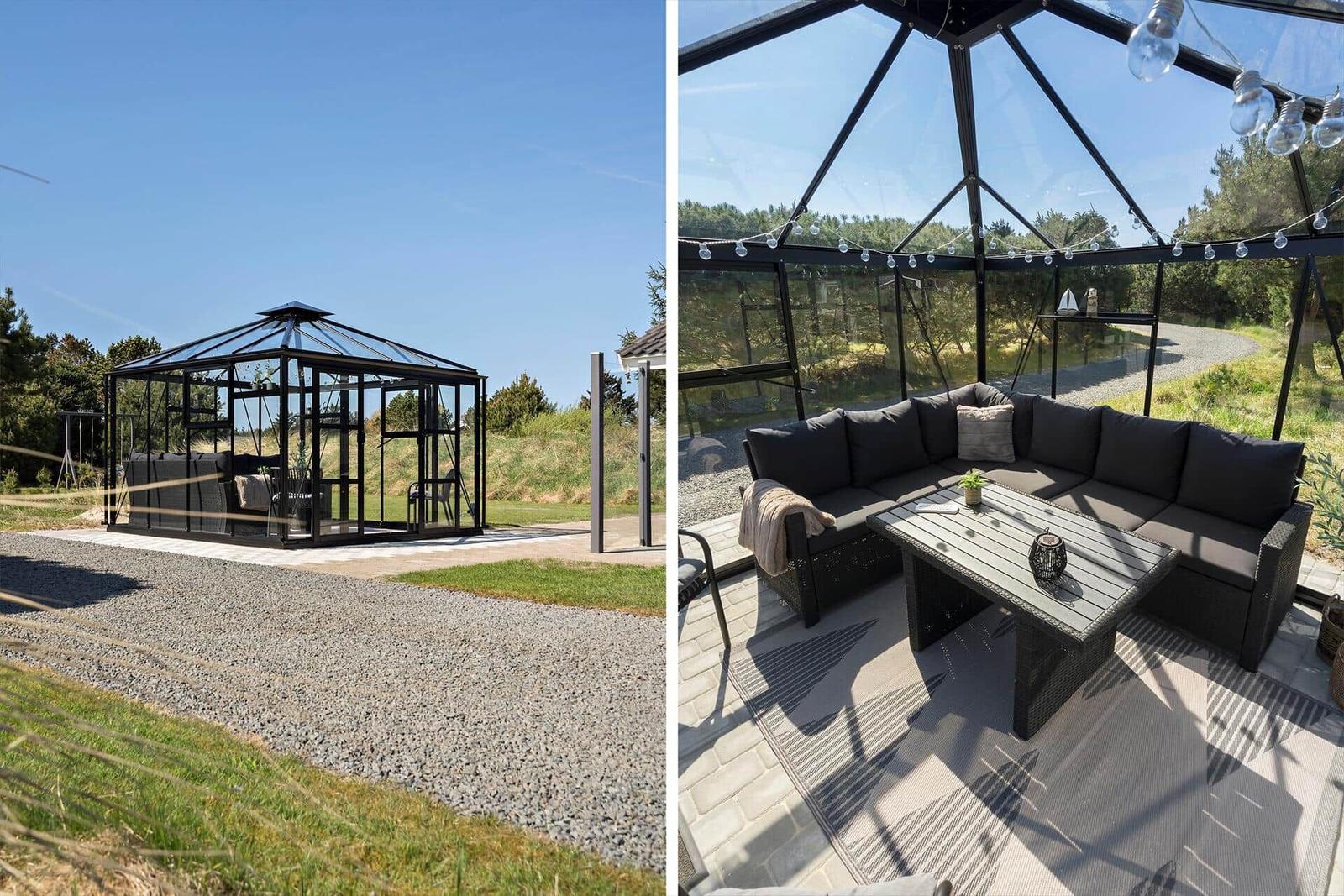 Glashaus mit Sitzgruppe und Tisch auf Terrasse. Außenbereich mit Gras und Bäumen.
