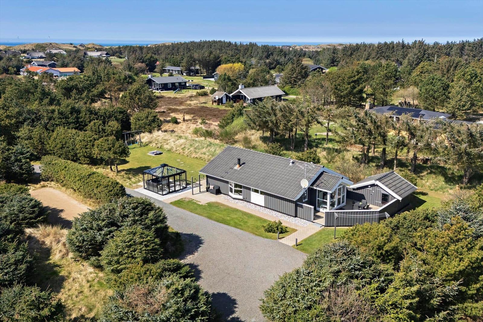 Moderne Villa mit Garten, Grillplatz und Blick auf Wald und Meer.