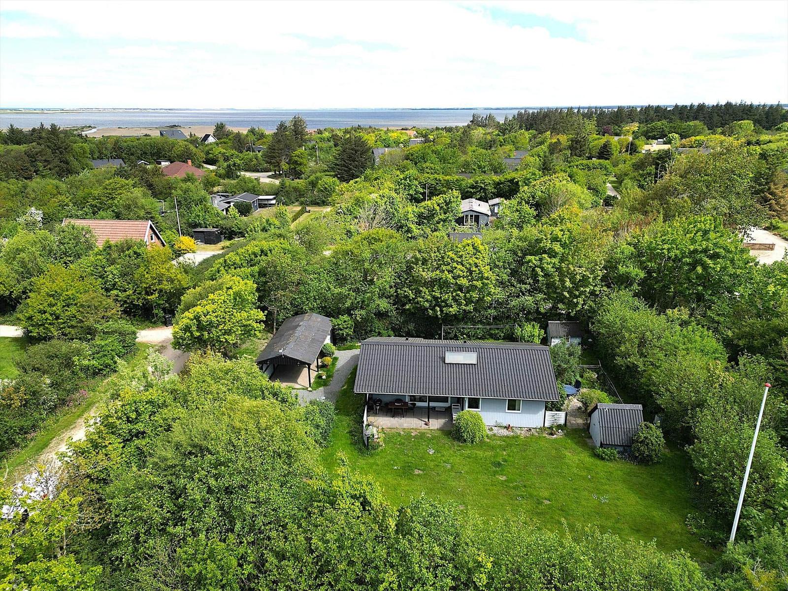 Ein Haus mit Garten und Blick auf Wasser und Wald