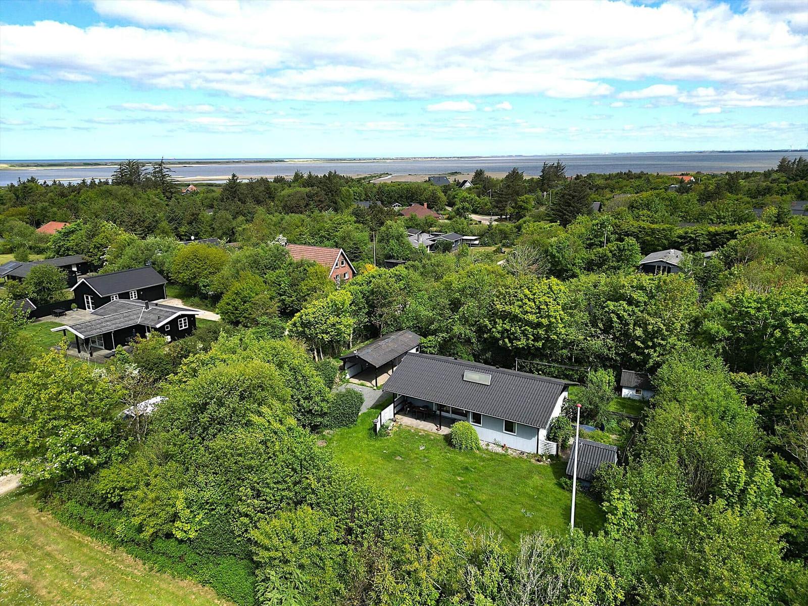 Haus mit Garten und Blick auf Wasser und Wald.