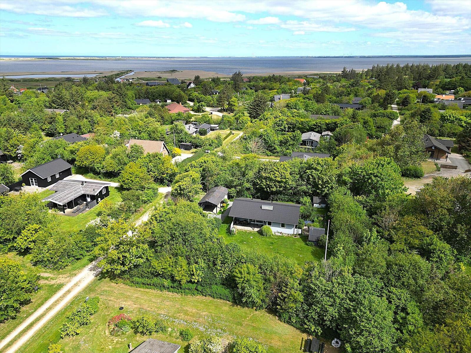 Luftbild von Ferienhäusern in grüner Umgebung mit Blick auf Wasser