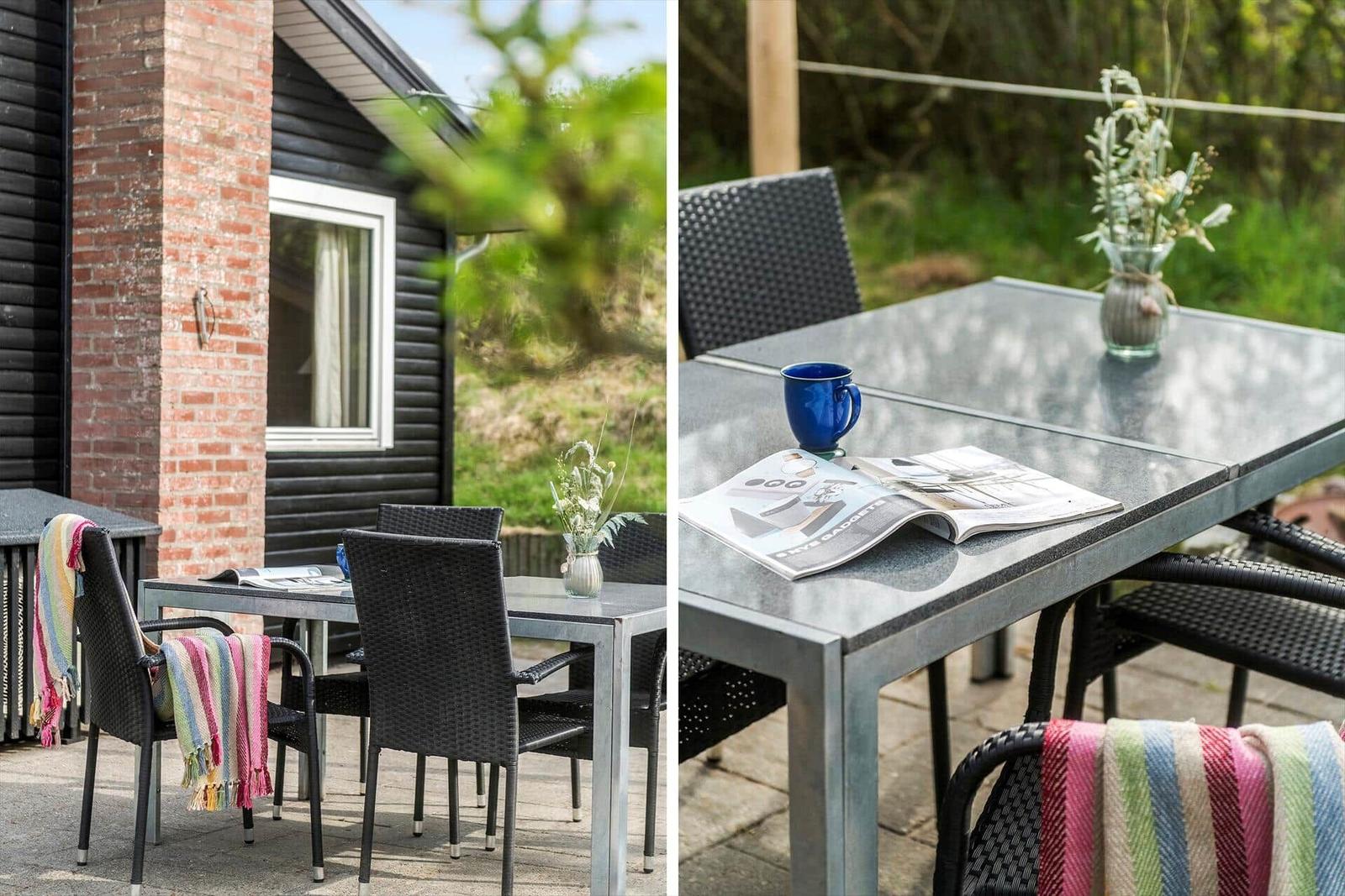 Terrasse mit Tisch, Stühlen und einem blauen Becher.