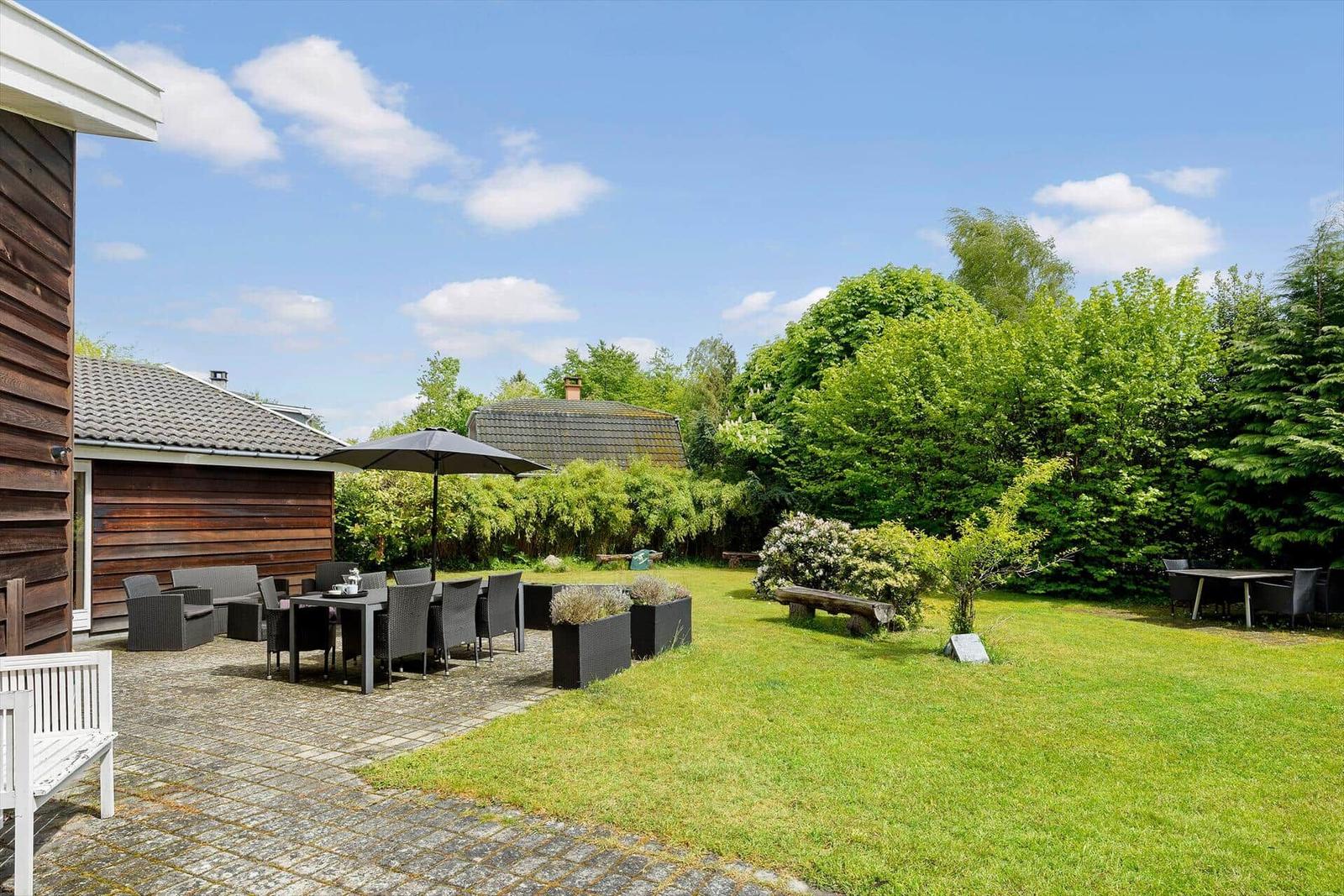 Garten mit Sitzgelegenheiten, Grillbereich und Grünflächen.