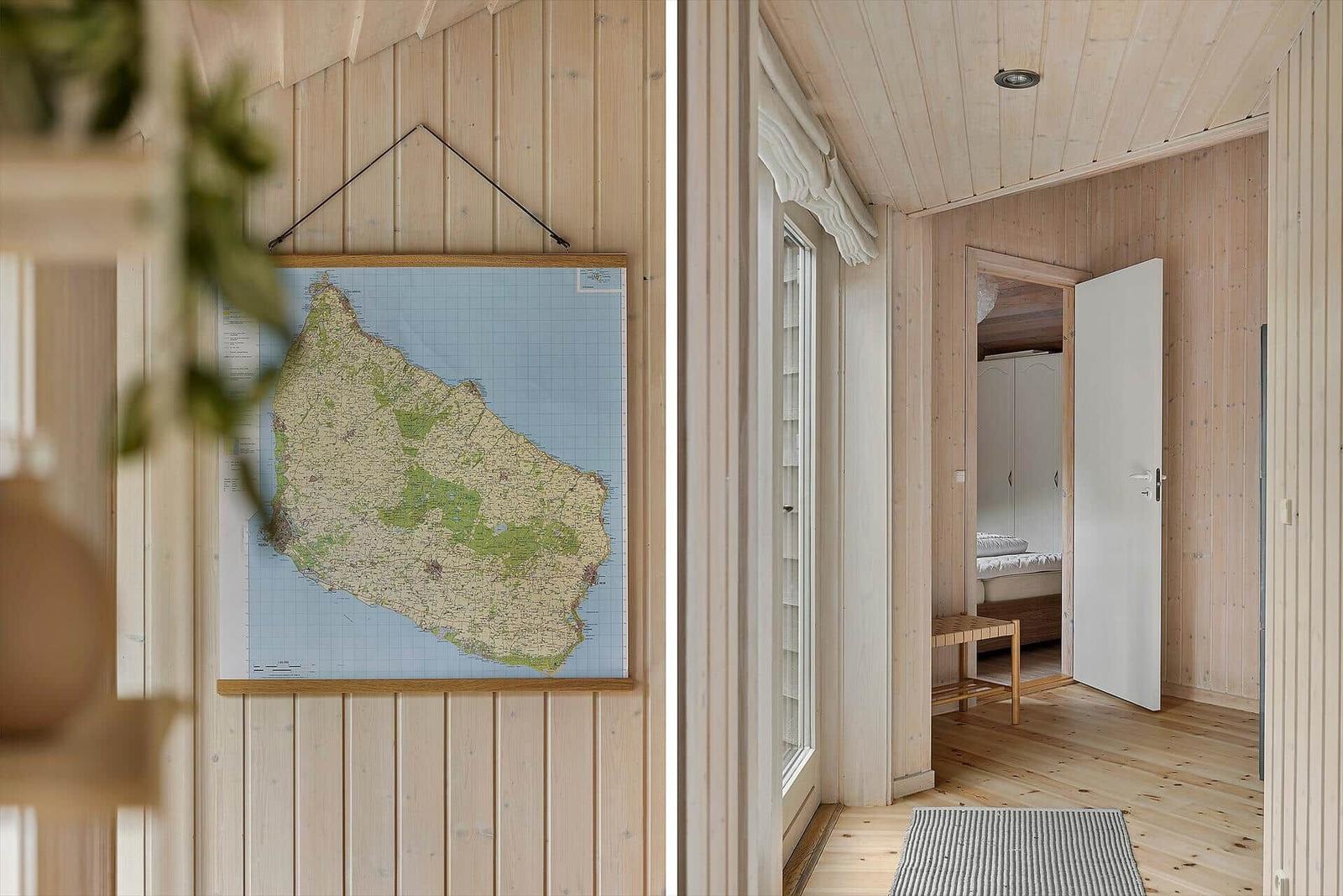 Wohnung mit Holzwand und Karte an der Wand. Tür führt in Schlafzimmer mit Bett und Schrank.