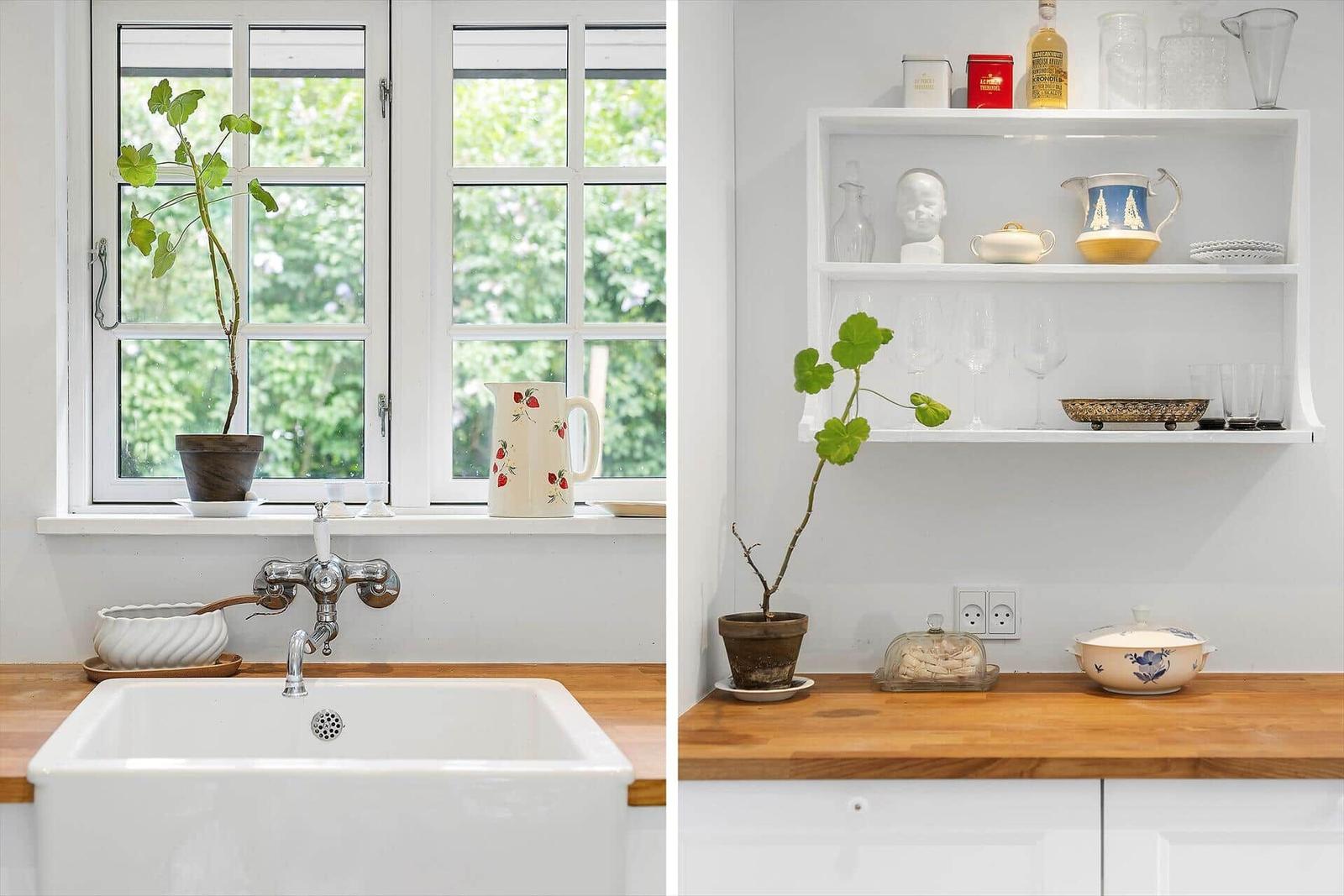 Kitchen with wooden countertop, white sink, and window with plant.