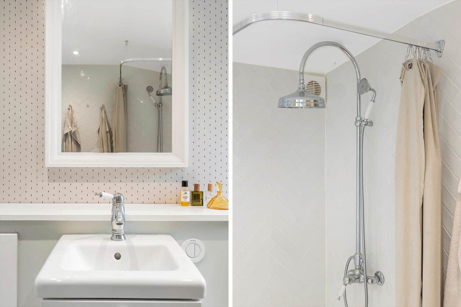 Bathroom with sink and shower. Tiled wall and mirror are visible.