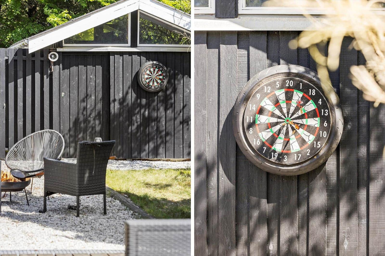 Außenbereich mit Dartscheibe an Holzwand und Sitzgelegenheiten