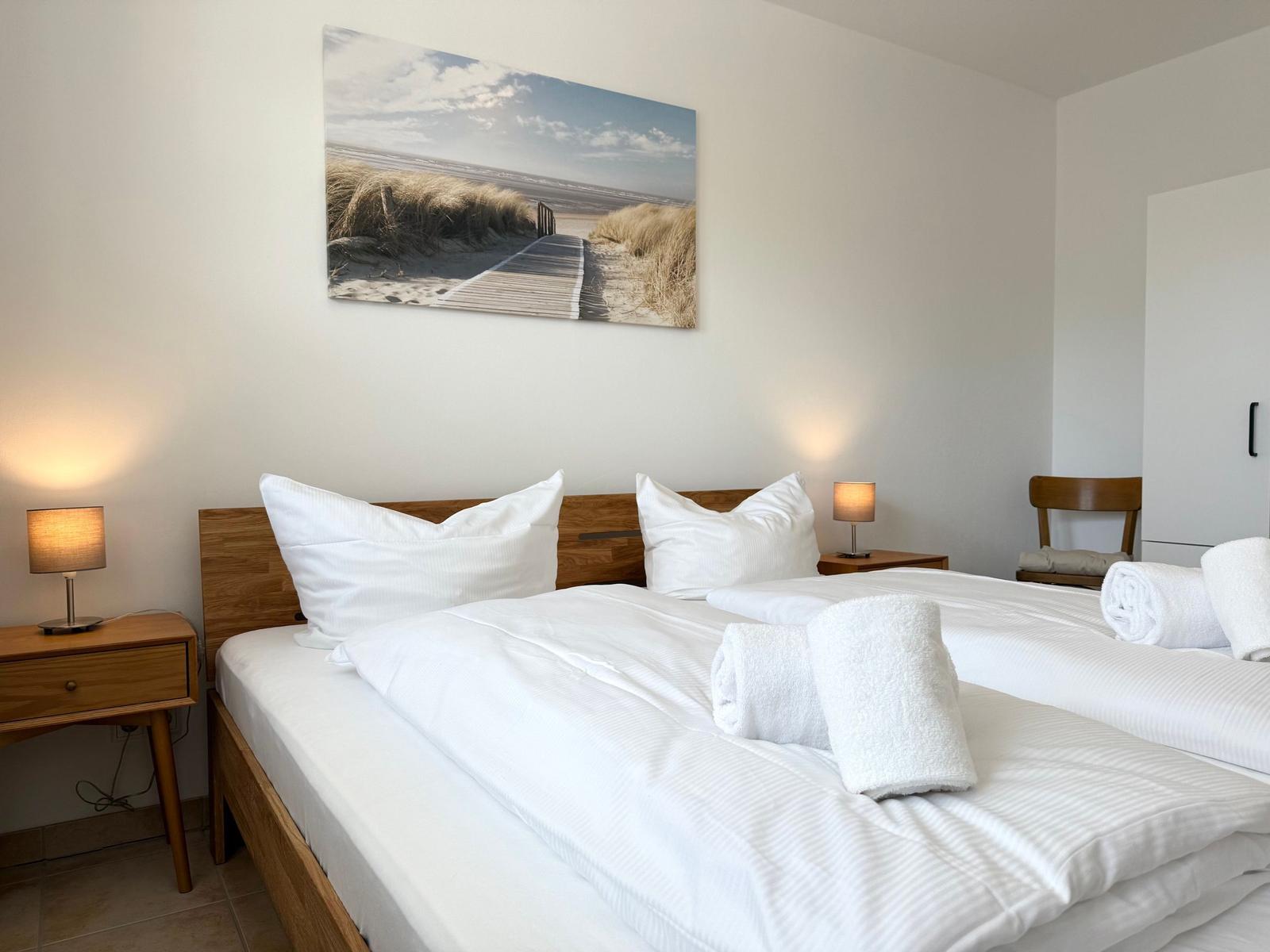 Schlafzimmer mit Bett, Nachttischen und Wandbild