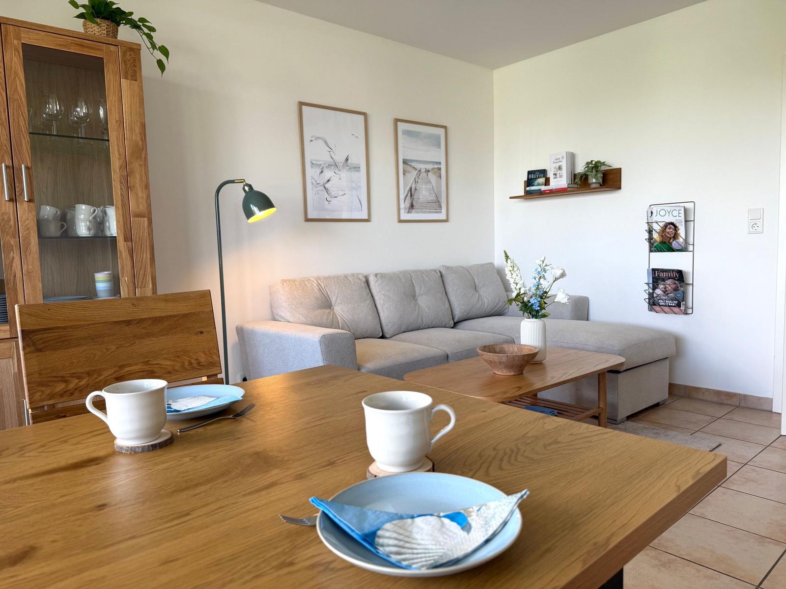 Essbereich mit Holztisch, Sofa und Küchenschränken