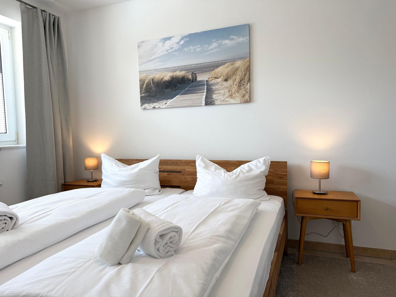 Ein Schlafzimmer mit einem Bett, zwei Nachttischen und einer Wanddekoration.