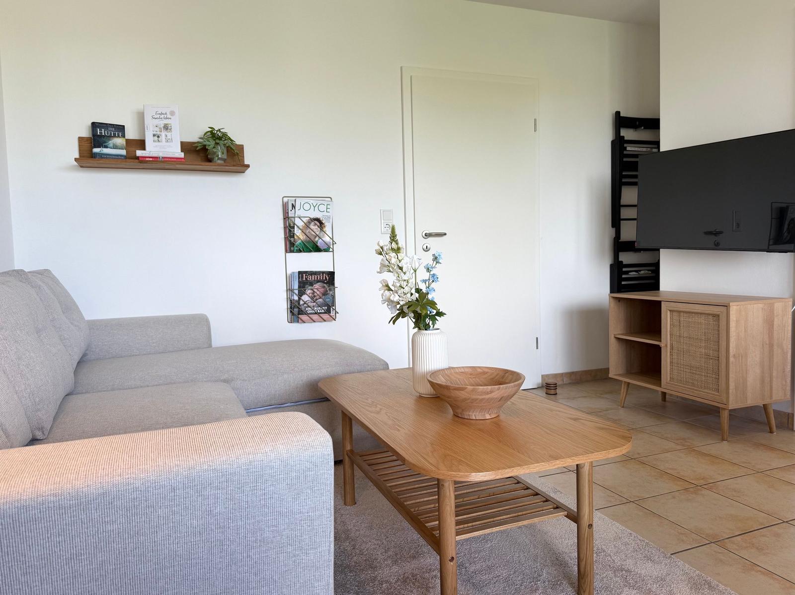 Wohnzimmer mit Sofa, Couchtisch und Fernseher