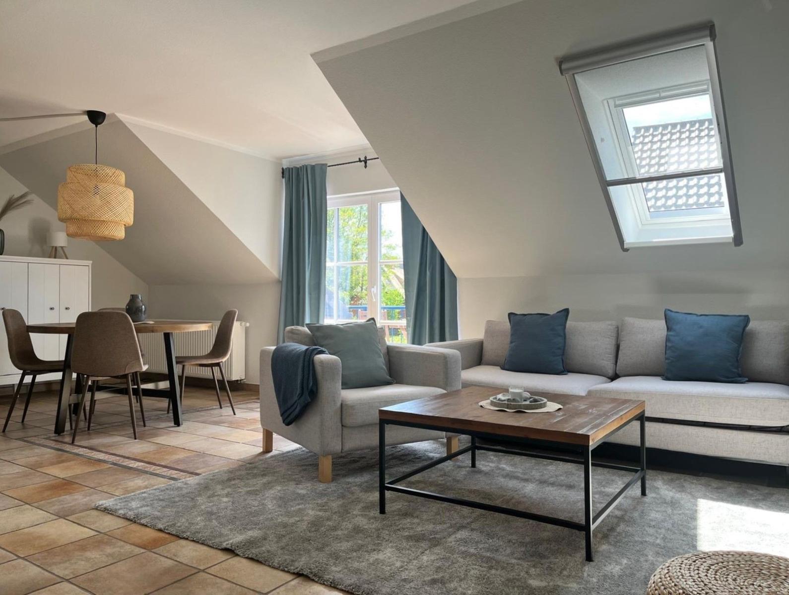 Wohn- und Essbereich mit Sofa, Tisch und Fenster