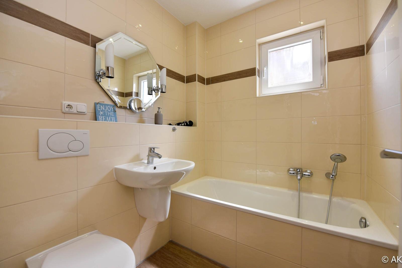 Badezimmer mit Badewanne, Waschbecken und Spiegel