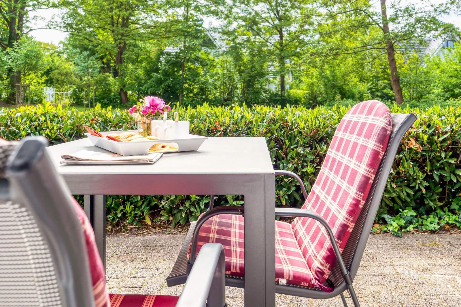 Außentisch mit Stühlen und Frühstück im Garten.