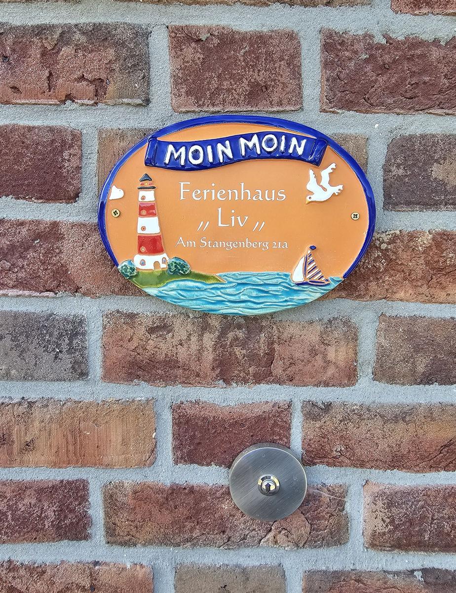 Ferienhaus Liv mit Leuchtturm- und Segelyacht-Dekoration an der Wand