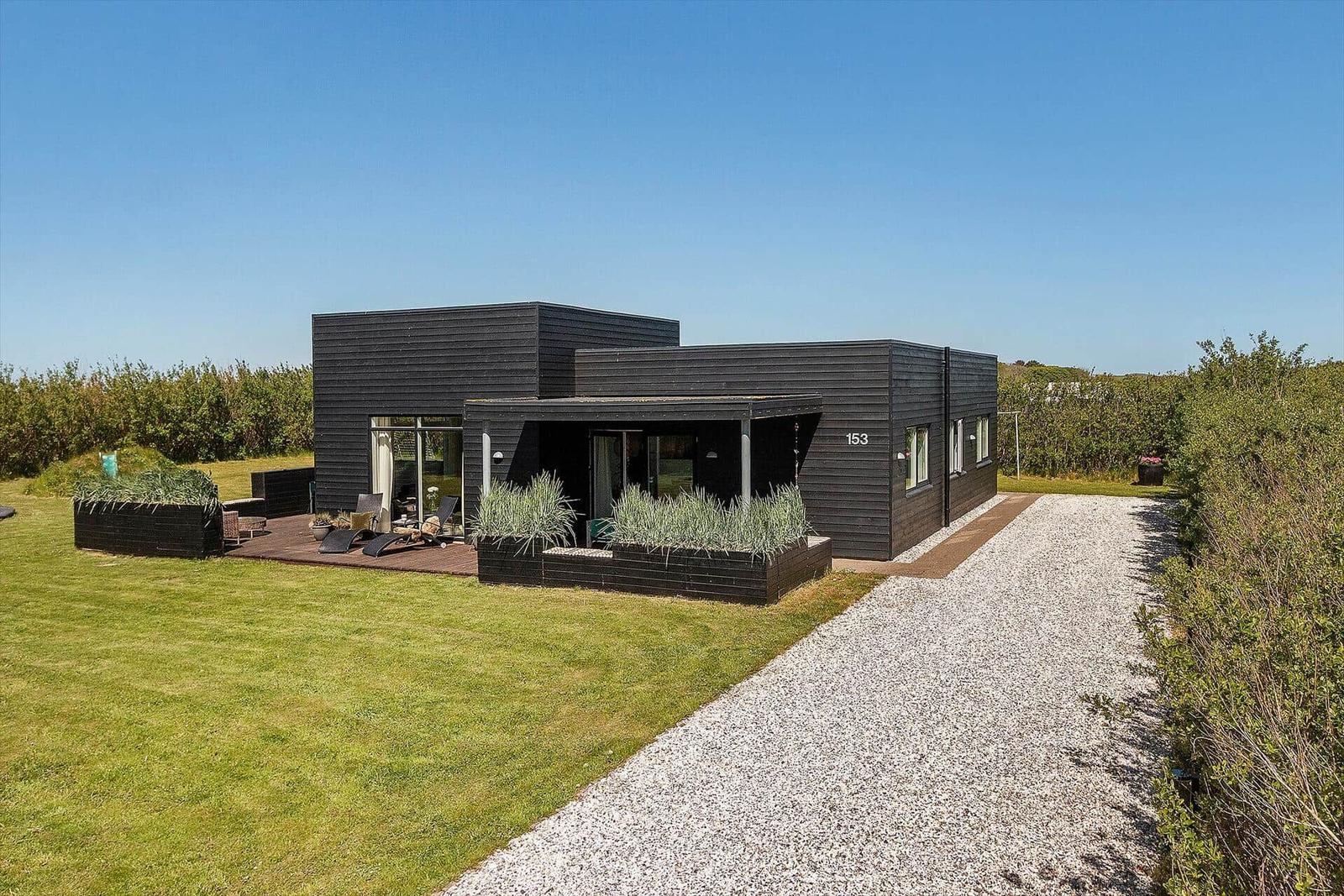 Moderne Villa mit Terrasse, Garten und Kiesweg. Hausnummer 153.