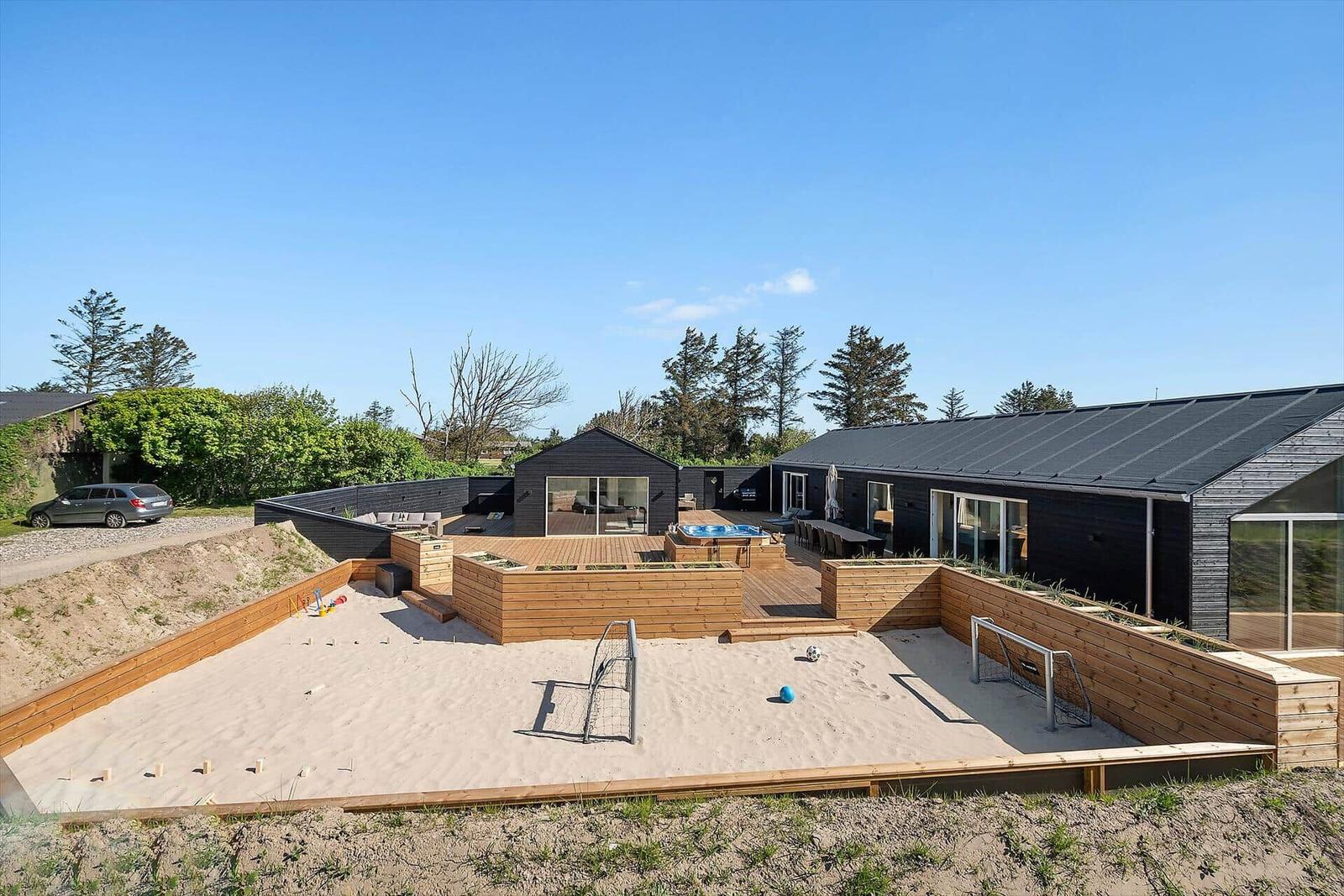 Modern house with sandbox, play area, and outdoor terrace.