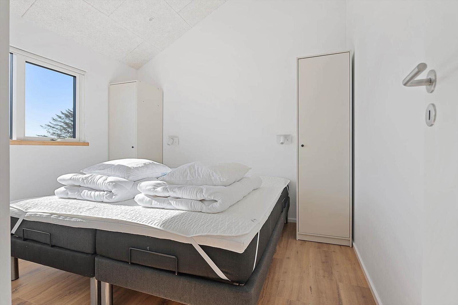 Bedroom with bed, window, and wardrobe.