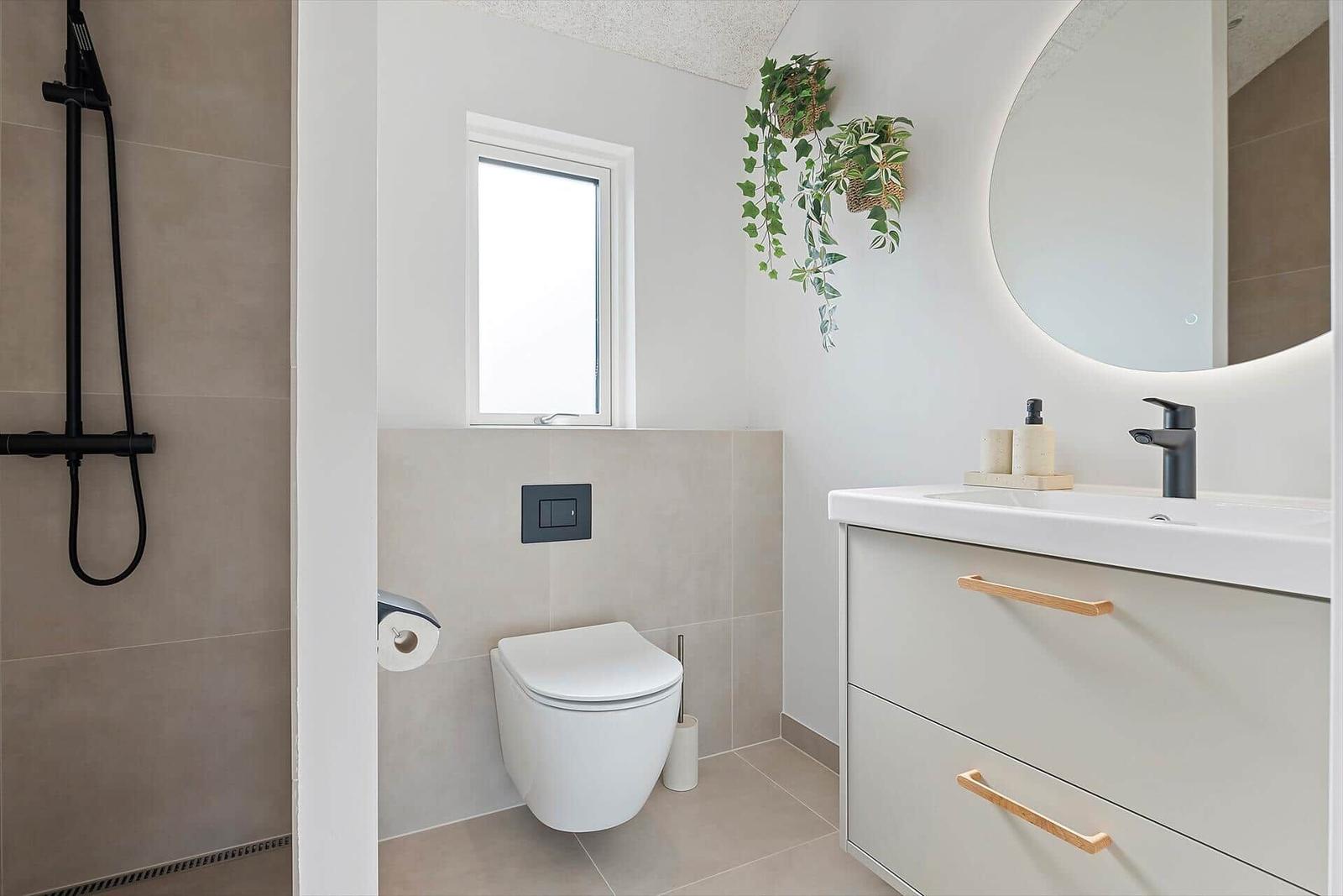 Bathroom with shower, toilet, and sink with mirror.