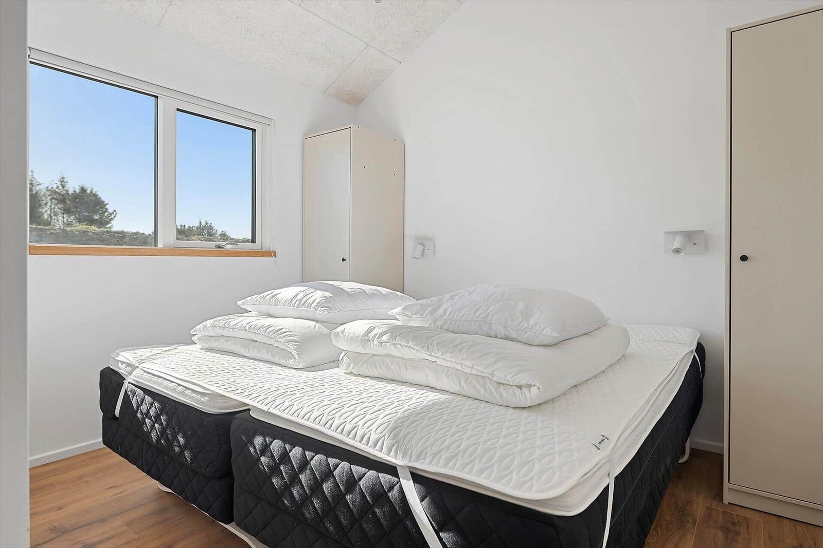 Bedroom with double bed, window, and wardrobe.