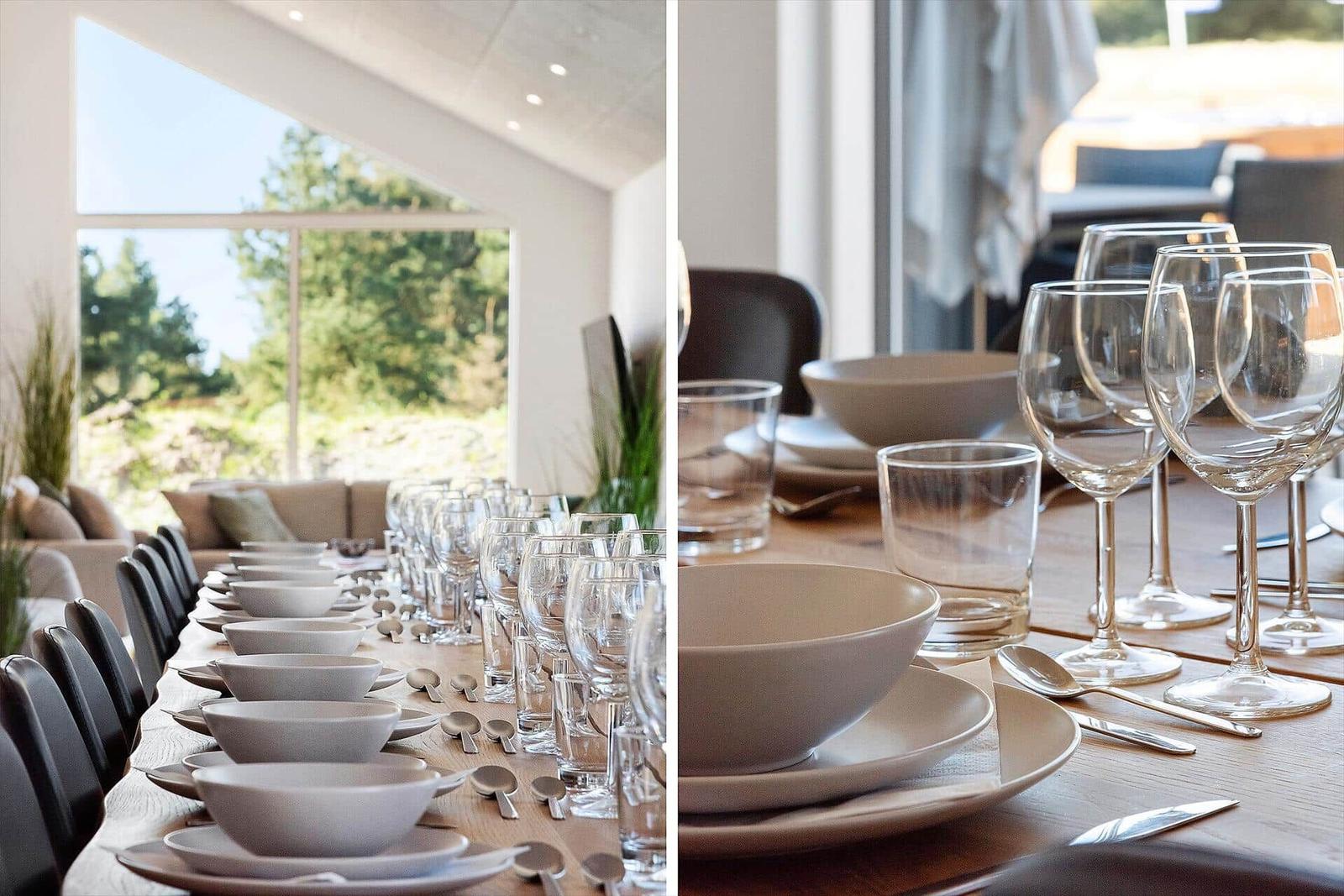 Long table set with dishes and glasses, view of garden and living area.