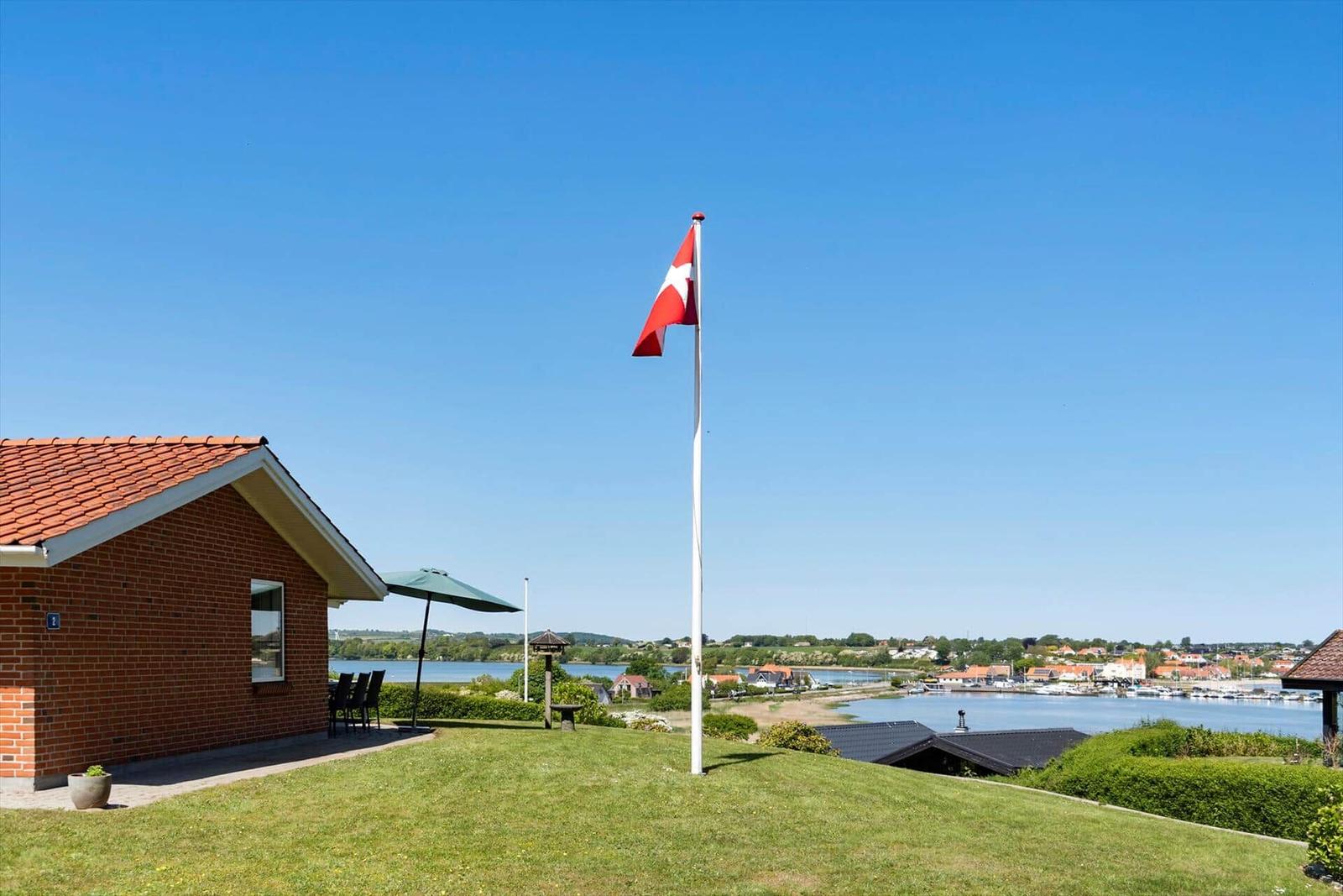 Haus mit Flagge und Blick auf Wasser und Dorf.