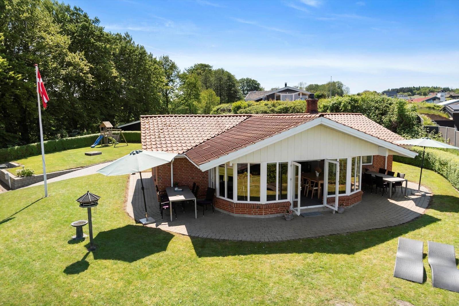Haus mit Terrasse, Grillplatz und Spielplatz im Garten.