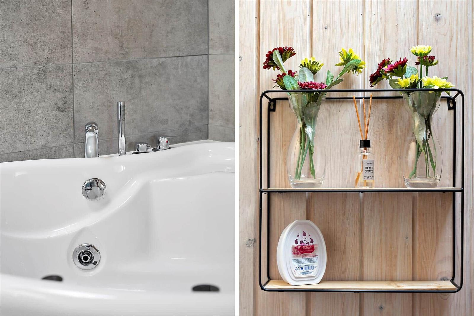 Bathtub with shower head and wooden wall with flowers and fragrance.
