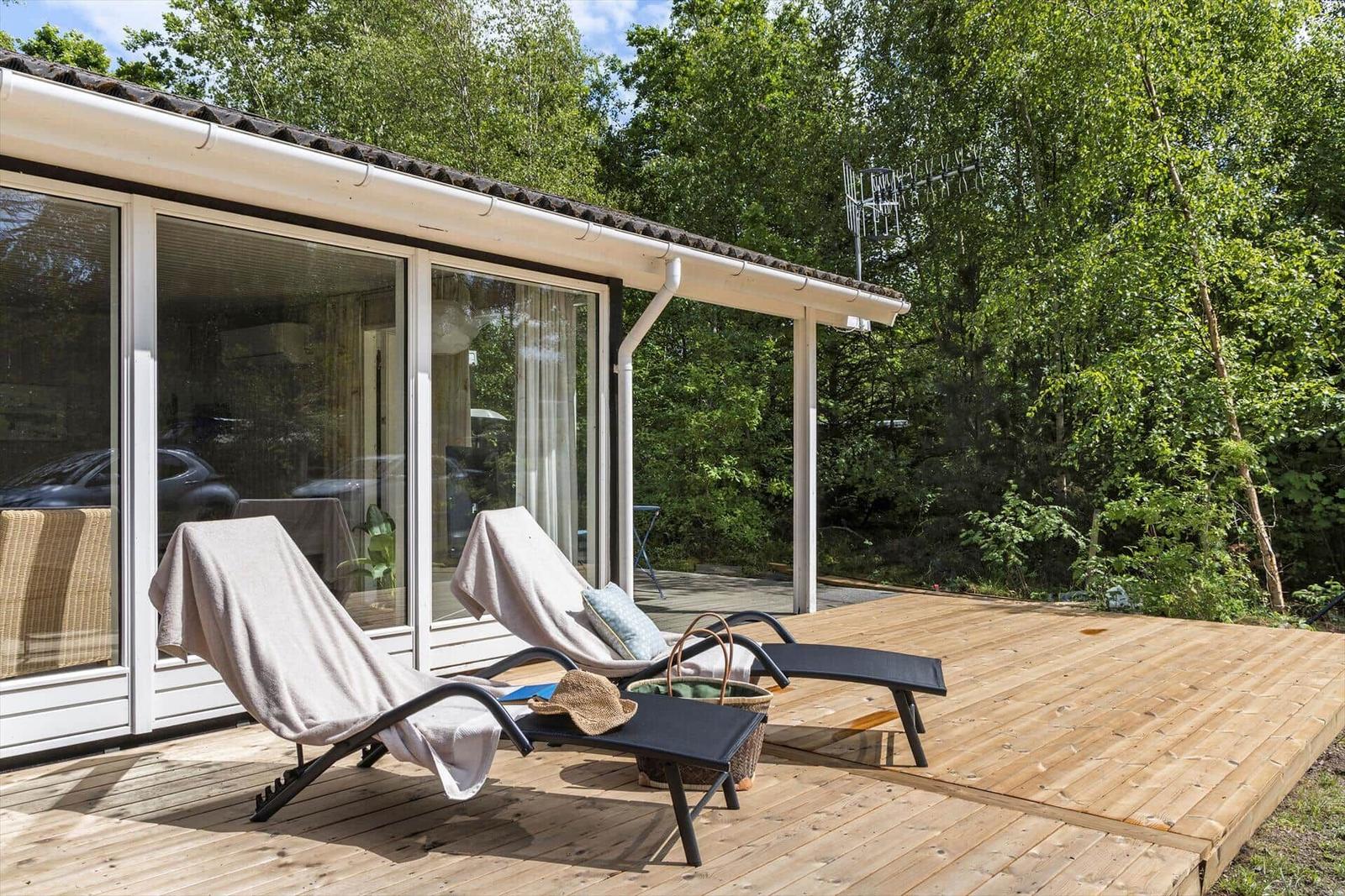 Terrasse mit Liegestühlen und Blick in den Wald