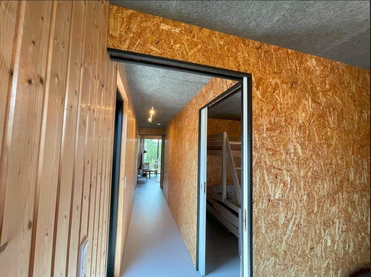 Flur mit Holzwänden und Schlafzimmer mit Doppelstockbett.