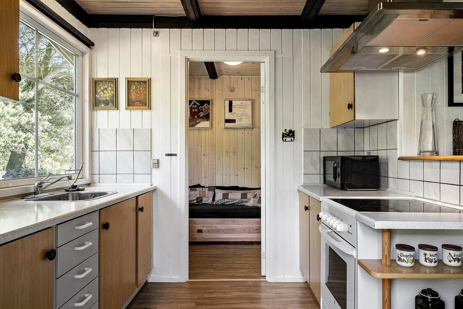Küche mit Blick auf Garten, Schlafzimmer im Hintergrund.
