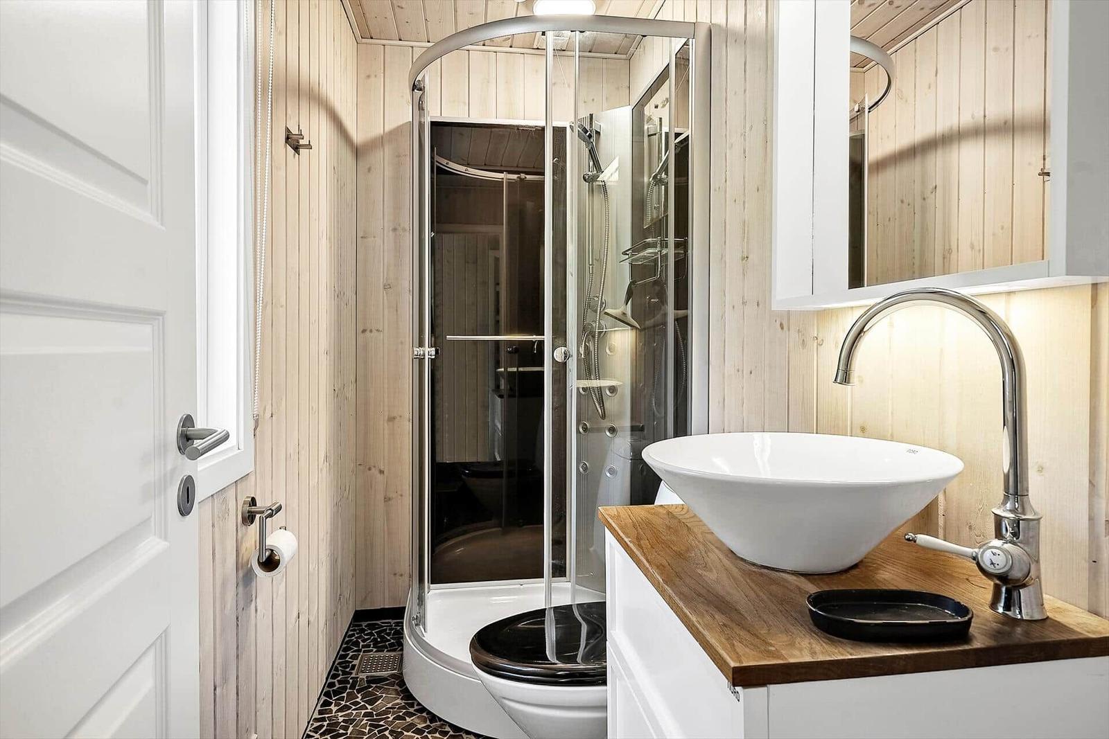 Badezimmer mit Dusche, Waschbecken und Toilette.