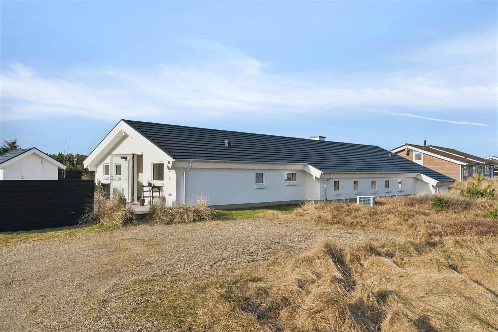 White house with black roof and garden