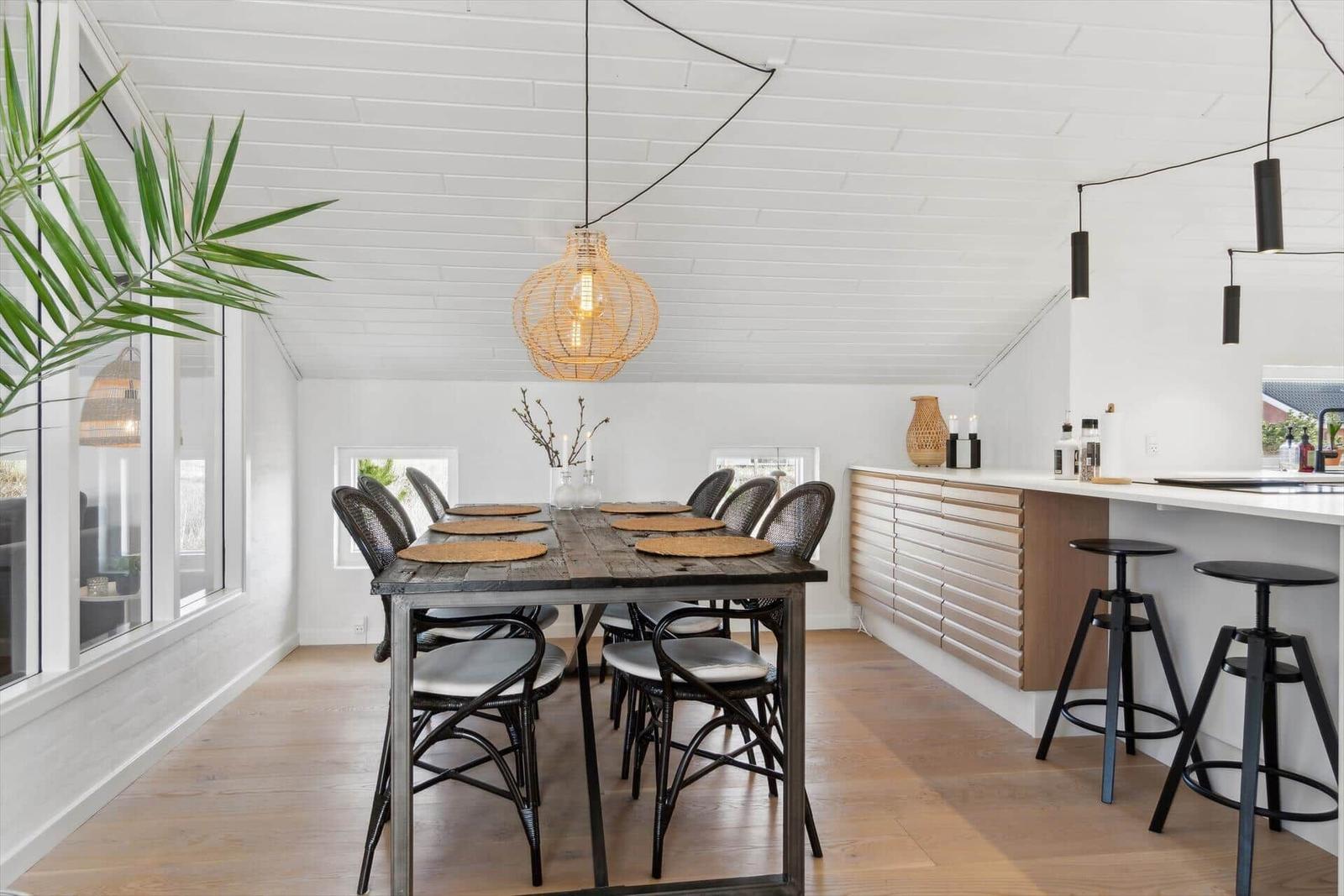 Dining area with wooden table, chairs, and kitchen counter