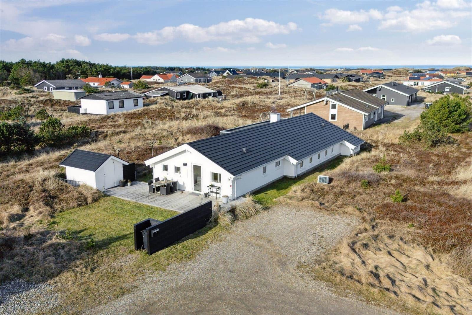 Modern white holiday home with terrace and view of the landscape.