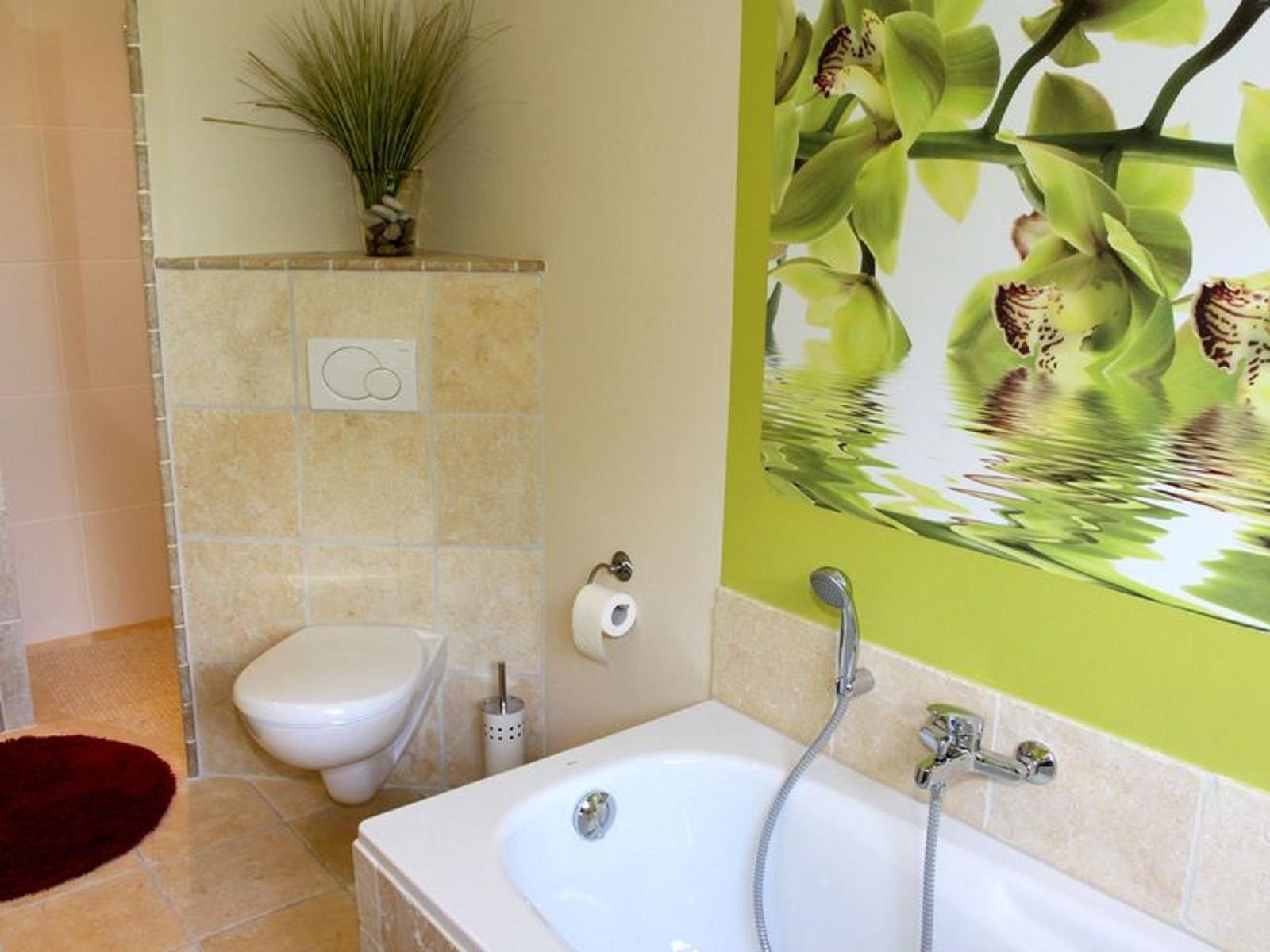 Bad mit Dusche, Toilette und Badewanne. Wandbild mit Orchideen.