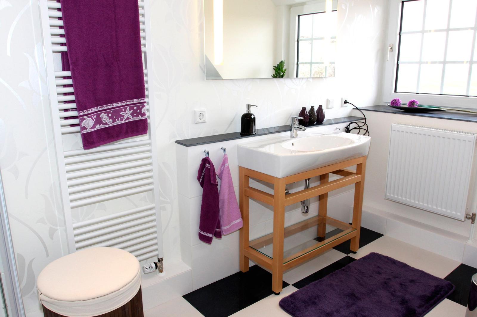 Badezimmer mit Waschbecken, Handtüchern und Fenster