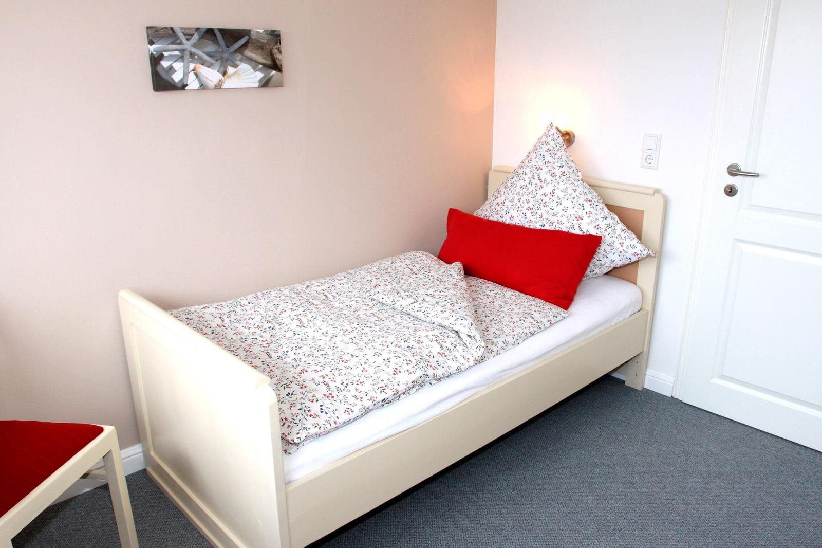 Ein Schlafzimmer mit einem Bett, einem Stuhl und einer Wanddekoration.