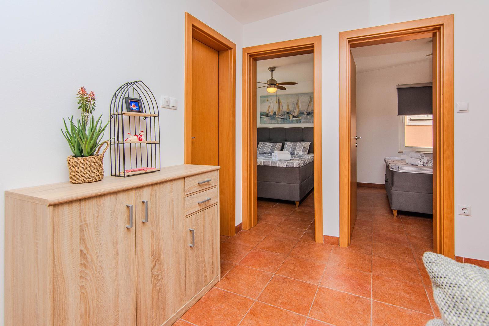 Flur mit Schrank, zwei Schlafzimmern und Terrakottboden