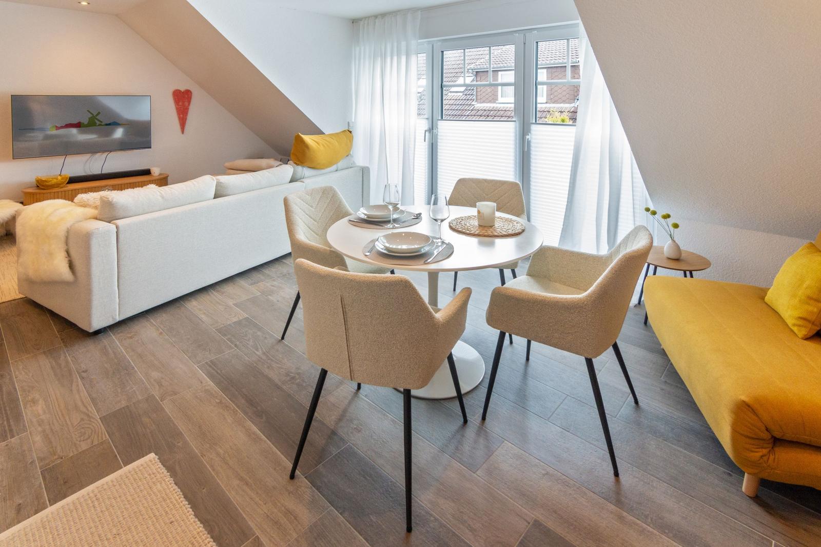 Wohn- und Essbereich mit Sofa, Esstisch und Fenster