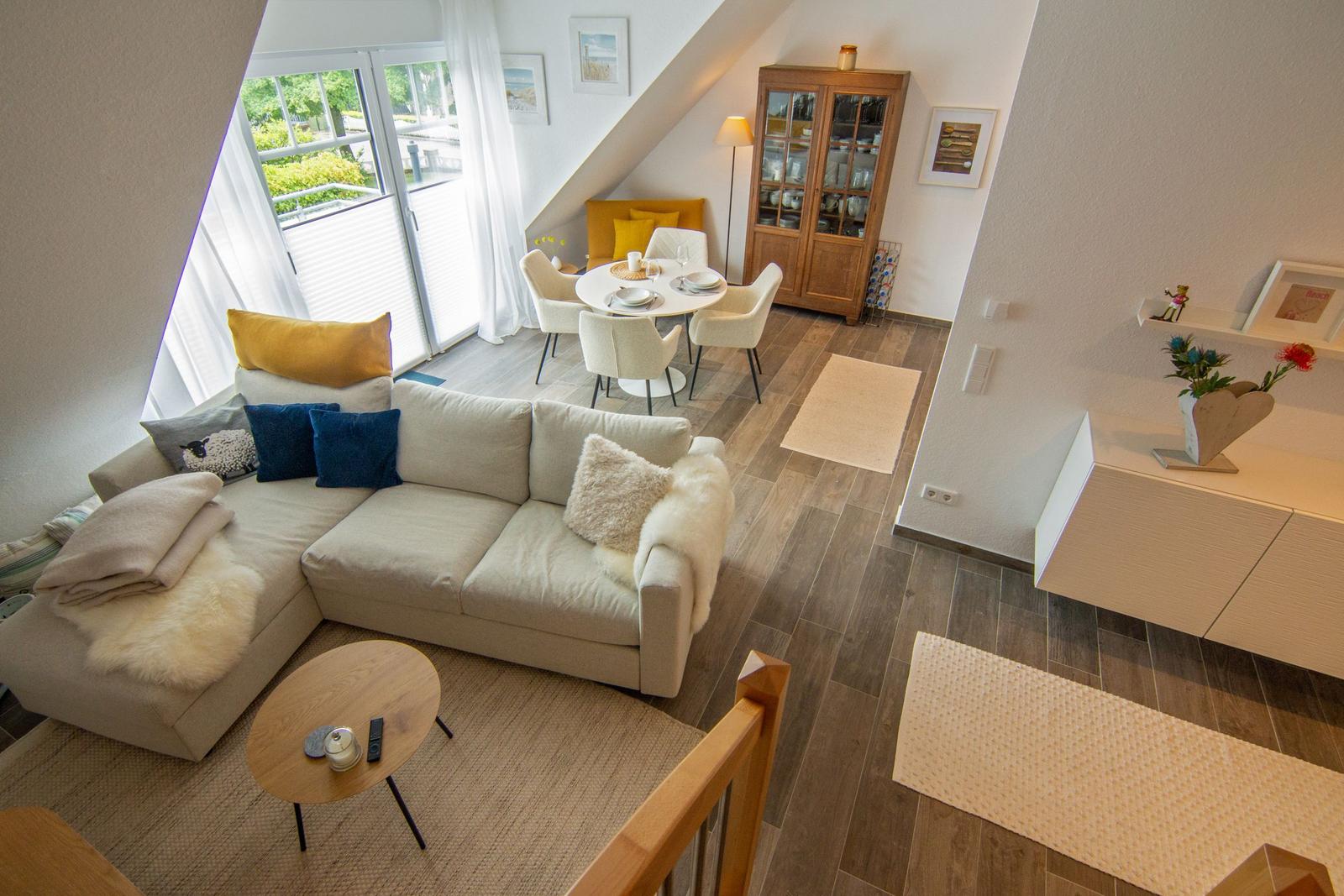 Wohn- und Essbereich mit Sofa, Tisch und Fenster zur Terrasse.