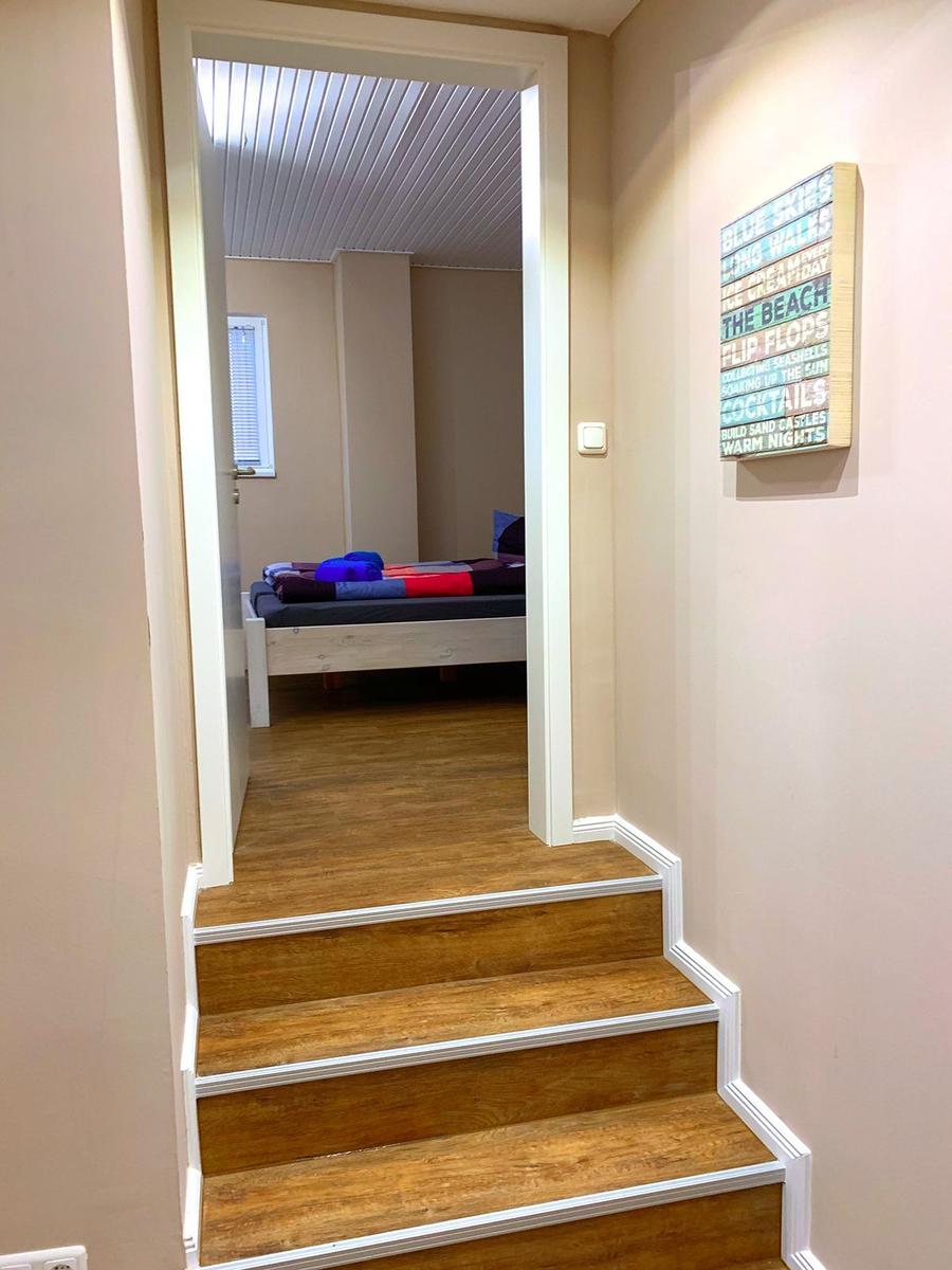 Treppenhaus führt zu einem Schlafzimmer mit Bett und Fenster.