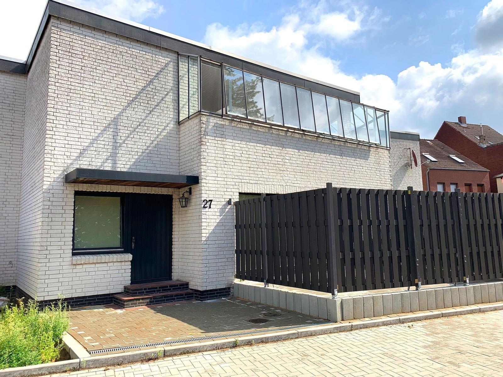 Moderne Villa mit weißen Ziegelwänden und großem Fensterband.