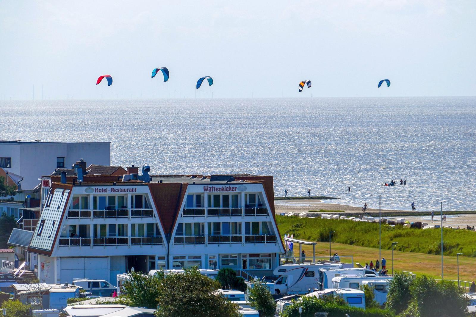 Hotel mit Blick auf das Meer und Kitesurfer.